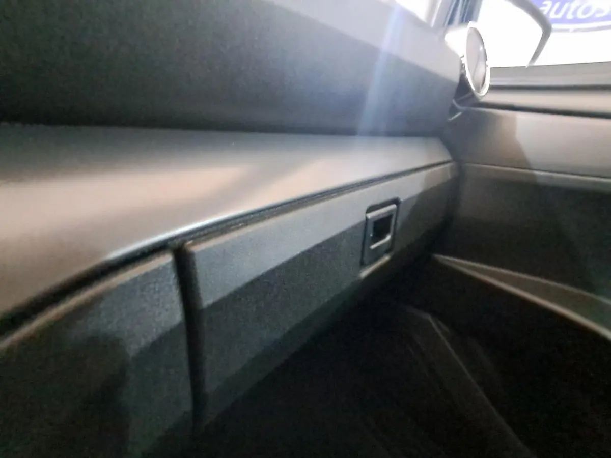 Vue intérieure côté passager de l’AIXAM AMBITION gris clair 2024, mettant en valeur la planche de bord épurée.