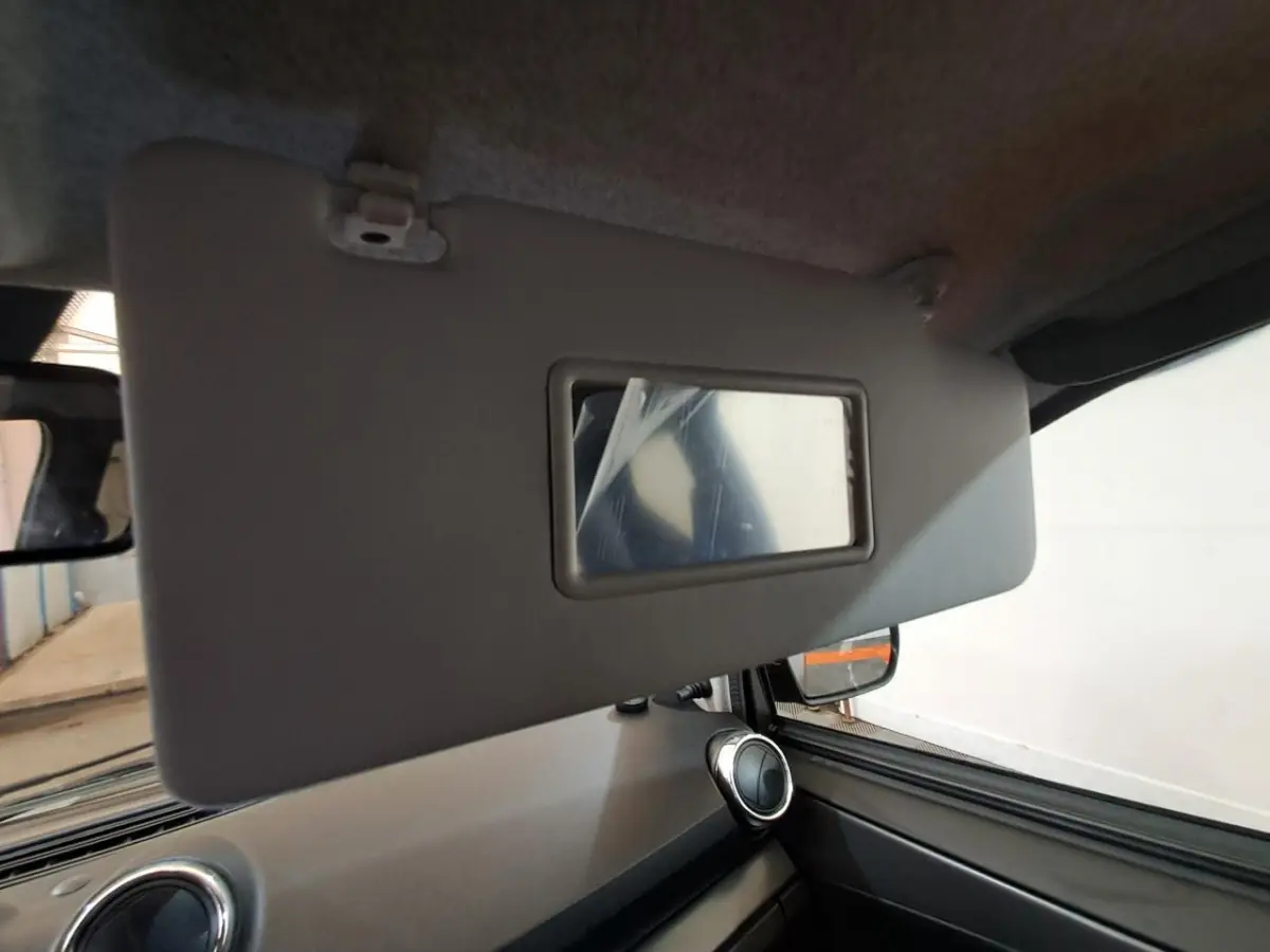 Détail du pare-soleil côté conducteur avec miroir intégré dans l’habitacle gris de l’Aixam Ambition 2024.