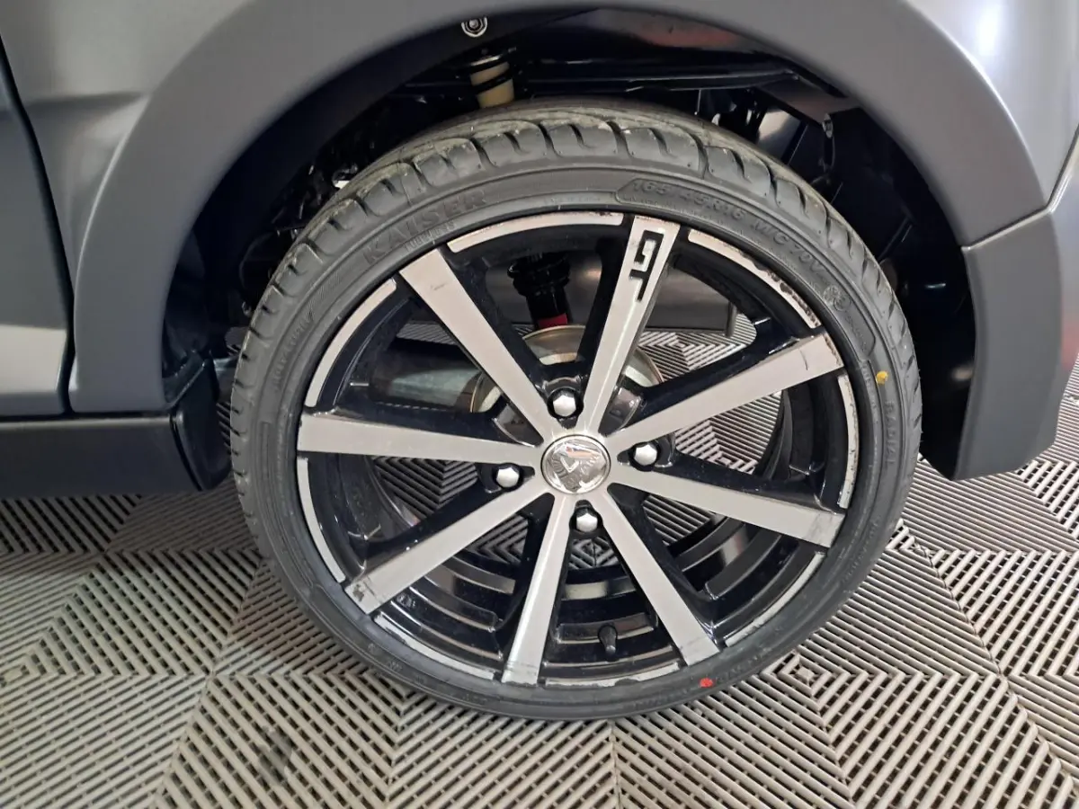 Gros plan sur la jante alliage 16’’ noires diamantées côté gauche de l’Aixam Ambition gris clair 2024.