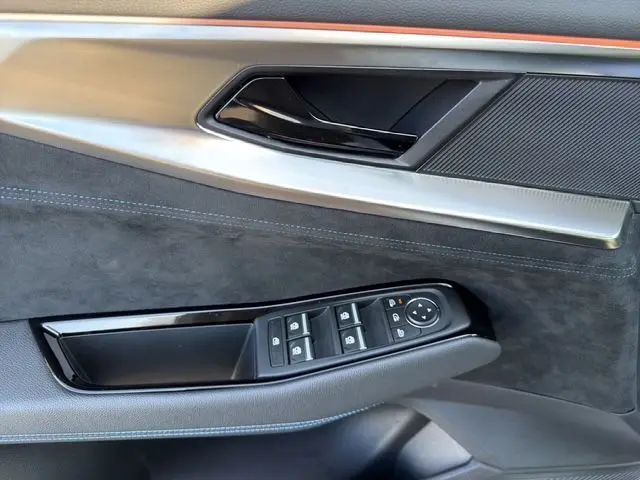 Détail intérieur de la porte côté gauche du Renault Austral 2025 blanc nacré, avec commandes de vitres et poignée noire.