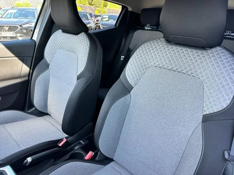 Vue intérieure rapprochée des sièges avant gris clair et noir de la Renault Clio 2025, tissu avec motif 3D.