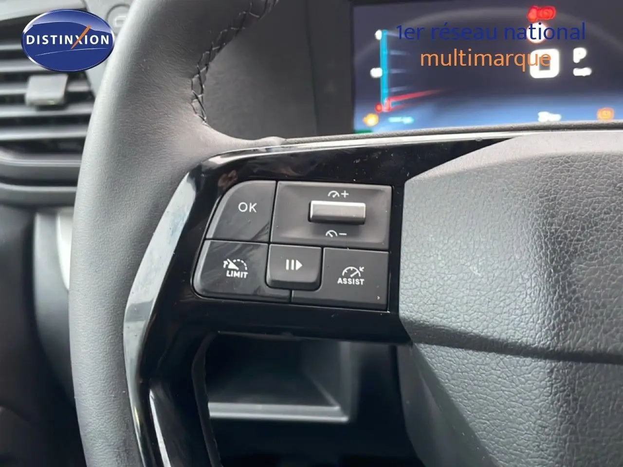 Gros plan sur les commandes de régulateur de vitesse au volant en cuir noir du Citroën Jumpy Long gris titane.