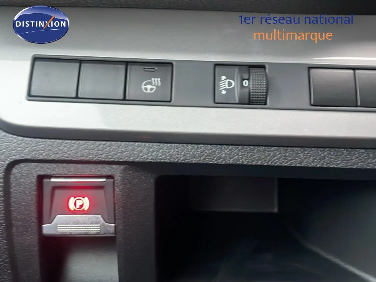 Gros plan sur les commandes du tableau de bord du Citroën Jumpy Long gris titane, avec bouton frein à main électronique allumé.