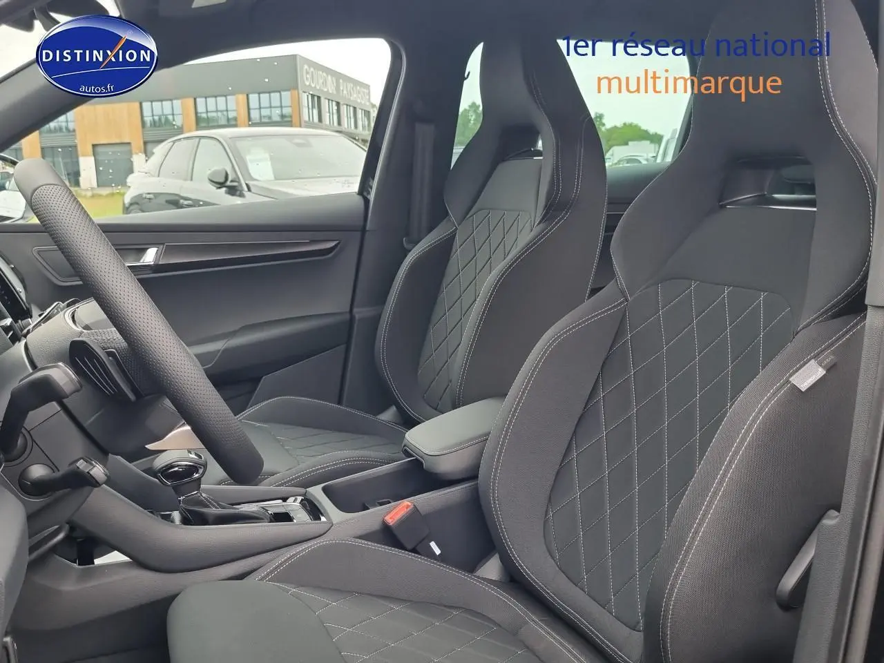 Intérieur du Skoda Karoq noir 2025, vue côté gauche sur sièges sport avec surpiqûres et accoudoir central.
