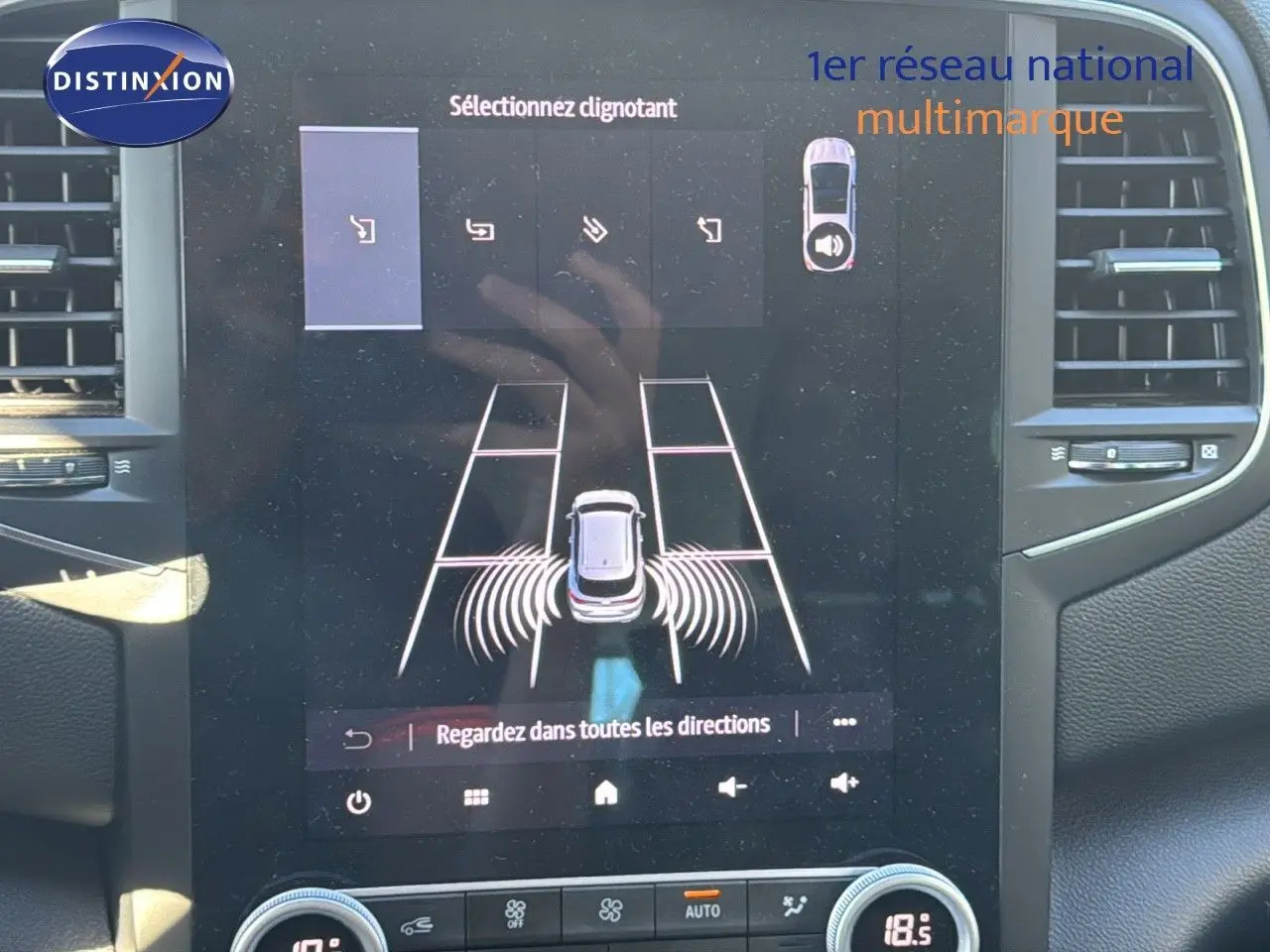 Écran tactile intérieur de la Renault Mégane Break gris titanium montrant l’aide au stationnement avec capteurs actifs.