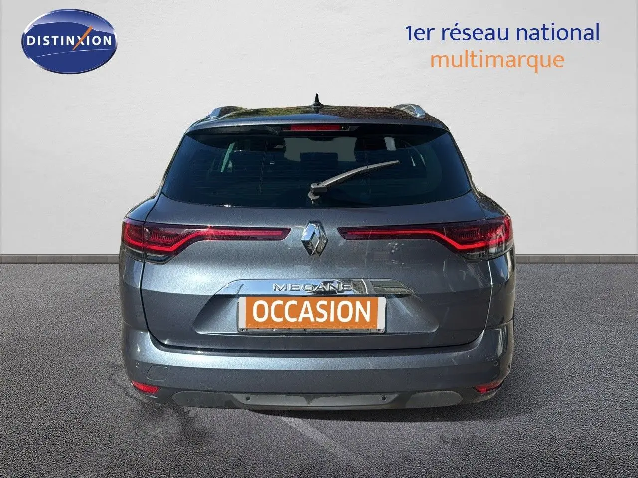 Vue arrière d’une Renault Mégane Break gris titanium métallisé avec feux LED et plaque d’immatriculation orange "OCCASION".