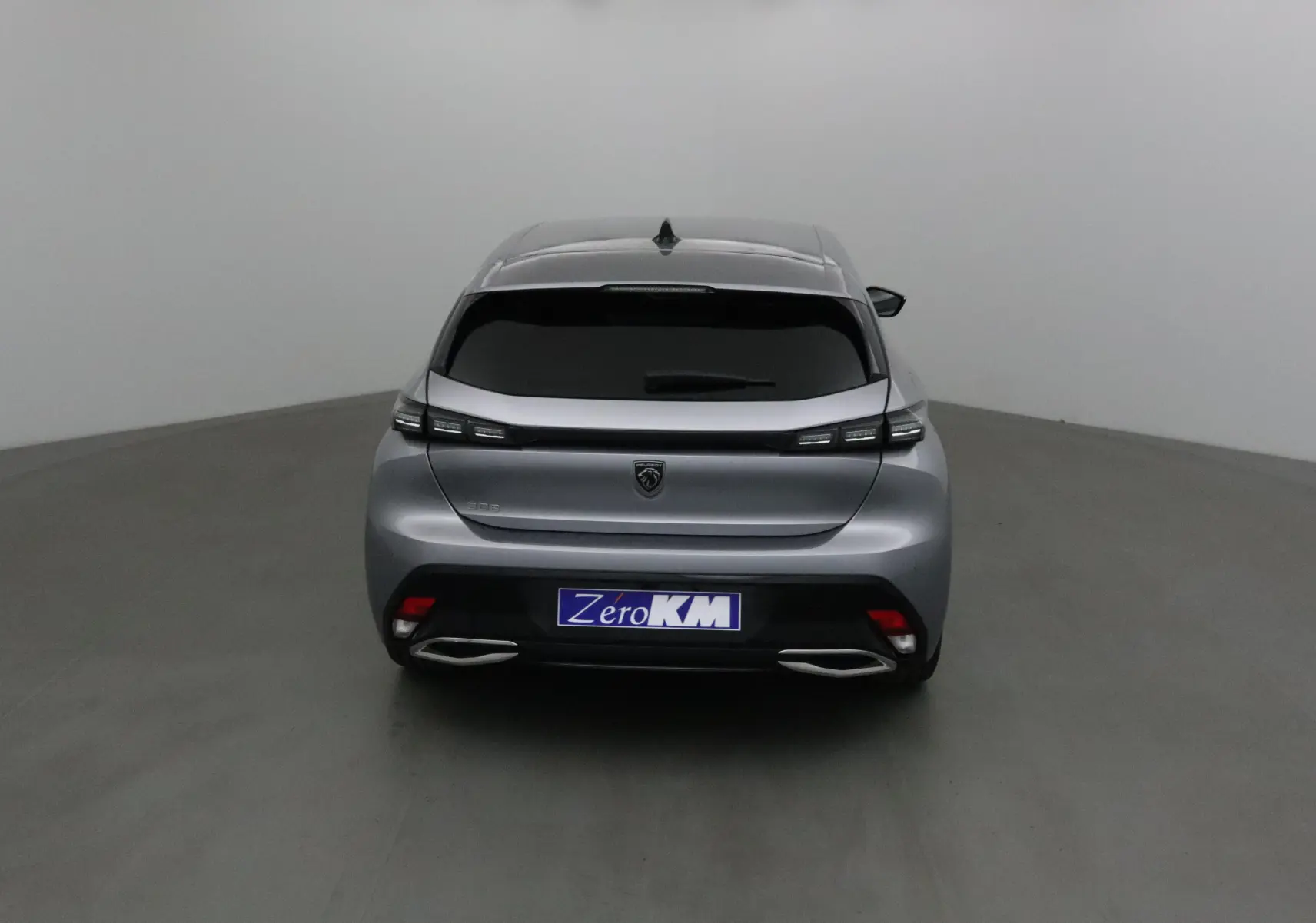 Vue arrière d'une Peugeot 308 gris Artense 2025 avec feux LED et double sortie d'échappement intégrée.