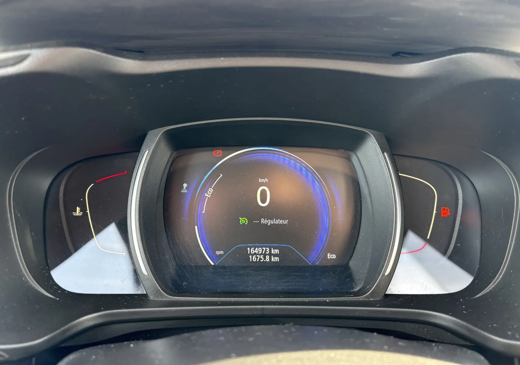 Tableau de bord numérique du Renault Kadjar 2015, affichant 0 km/h et 164973 km au compteur, vue frontale rapprochée.