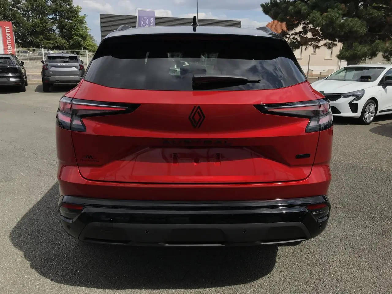 Vue arrière d'un Renault Austral 2025 bi-ton rouge et noir avec feux LED et logo Alpine visible.