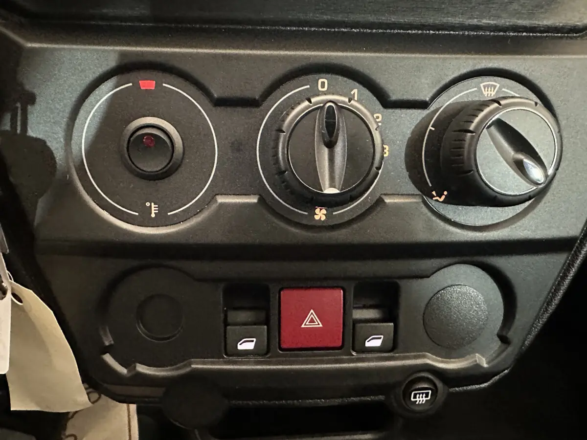 Gros plan sur les commandes de climatisation et les boutons de l’Aixam Ambition E City Pack 2026, tableau de bord noir.