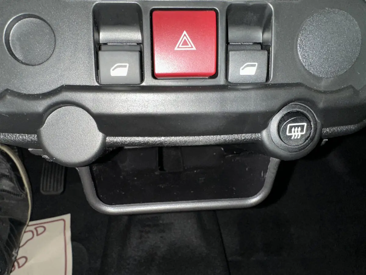 Détail du tableau de bord avec boutons de commande de vitres et bouton rouge de warning sur Aixam Ambition E City Pack 2026.