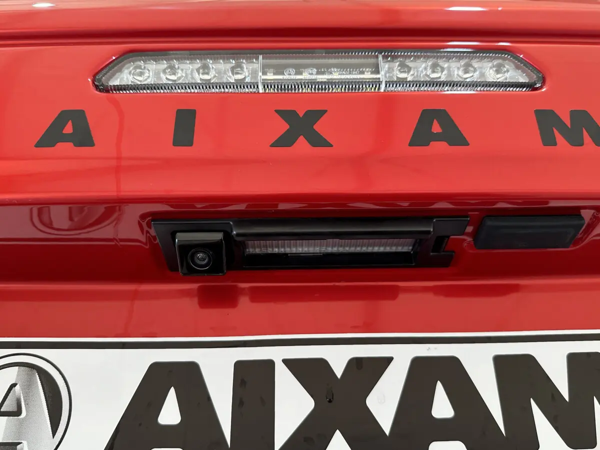 Gros plan sur la caméra de recul et le feu stop arrière du coffre rouge de l'AIXAM AMBITION E CITY PACK 2026.