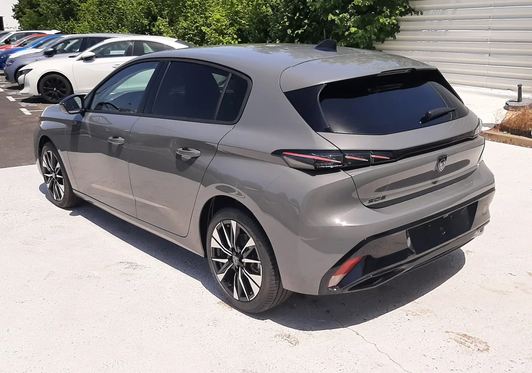 Peugeot 308 gris sélénium vue 3/4 arrière droit, avec feux arrière LED et jantes alliage bicolores.
