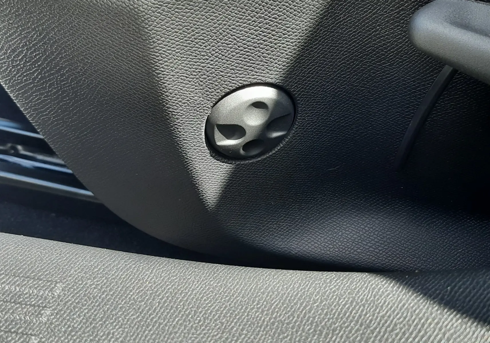 Détail du réglage manuel du siège côté conducteur sur Peugeot 308 gris Selenium, intérieur noir texturé.