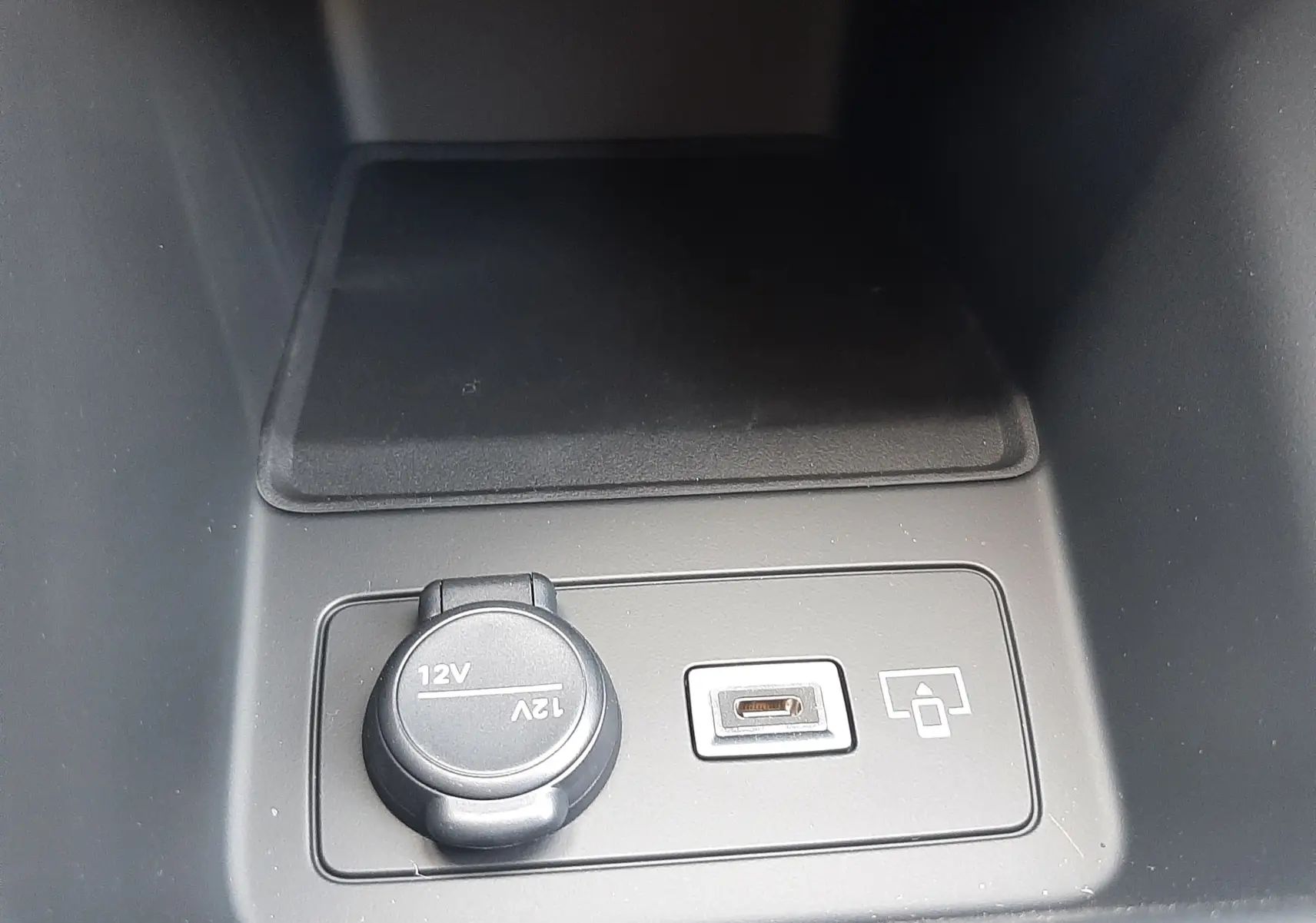 Prise 12V et port USB intégrés dans la console centrale de la Peugeot 308 gris sélénium, intérieur sobre.