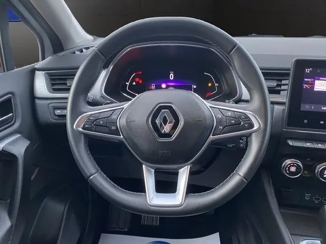 Vue intérieure centrée sur le volant noir du Renault Captur 2021, avec tableau de bord numérique et écran tactile visible à droite.