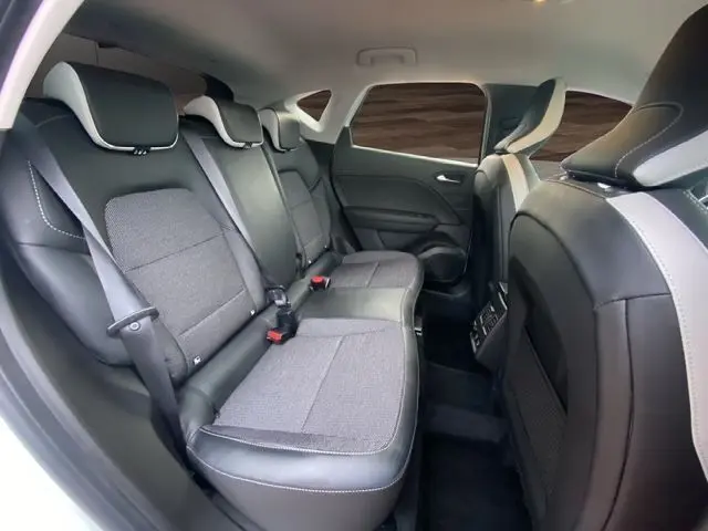 Vue intérieure arrière droite du Renault Captur DCI 115 EDC Intens 2021, sièges tissu gris et cuir noir, ambiance moderne et spacieuse.