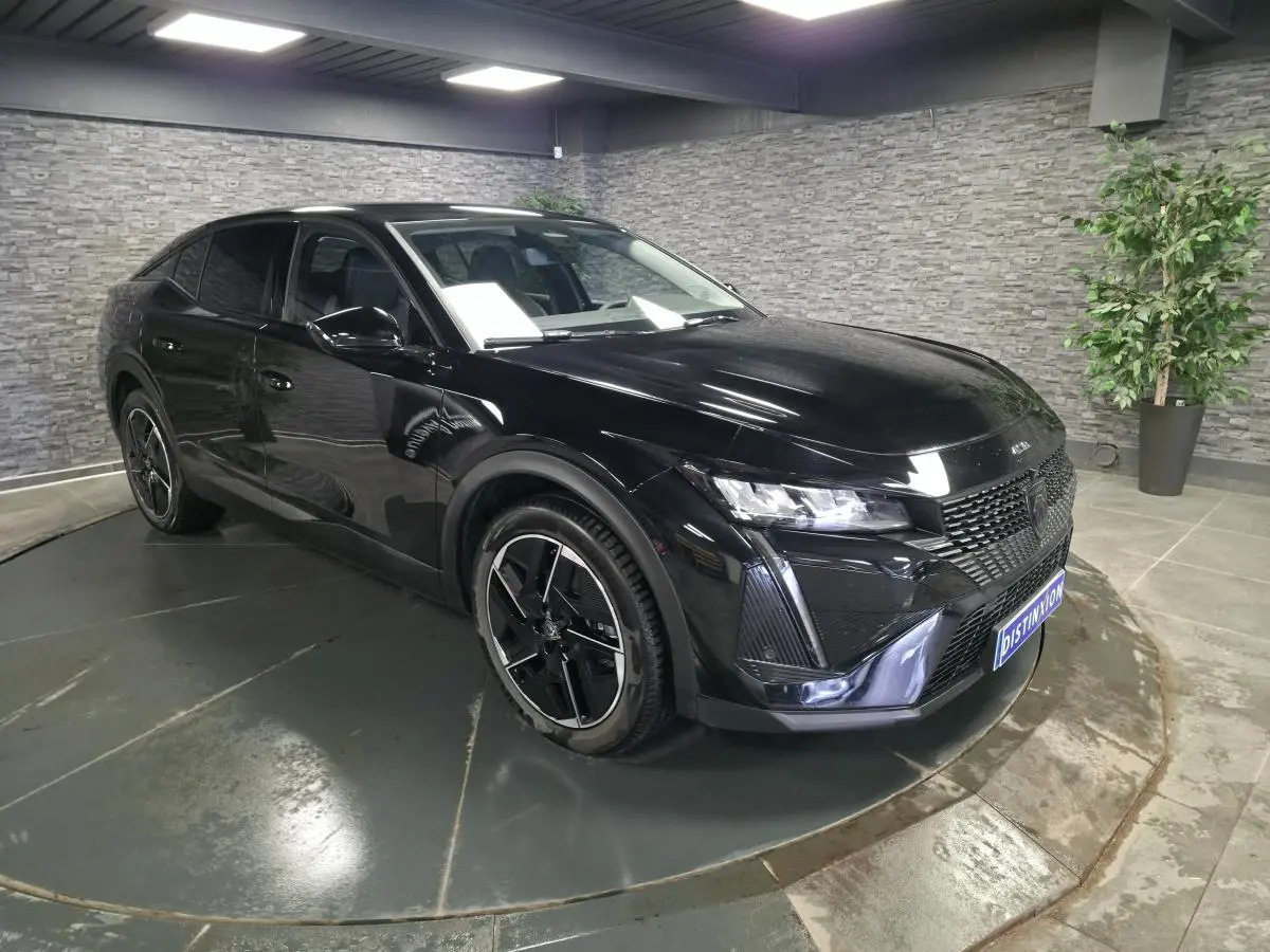 Peugeot 408 électrique noir Perla Nera en 3/4 avant droit, jantes alliage 19 pouces diamantées visibles.