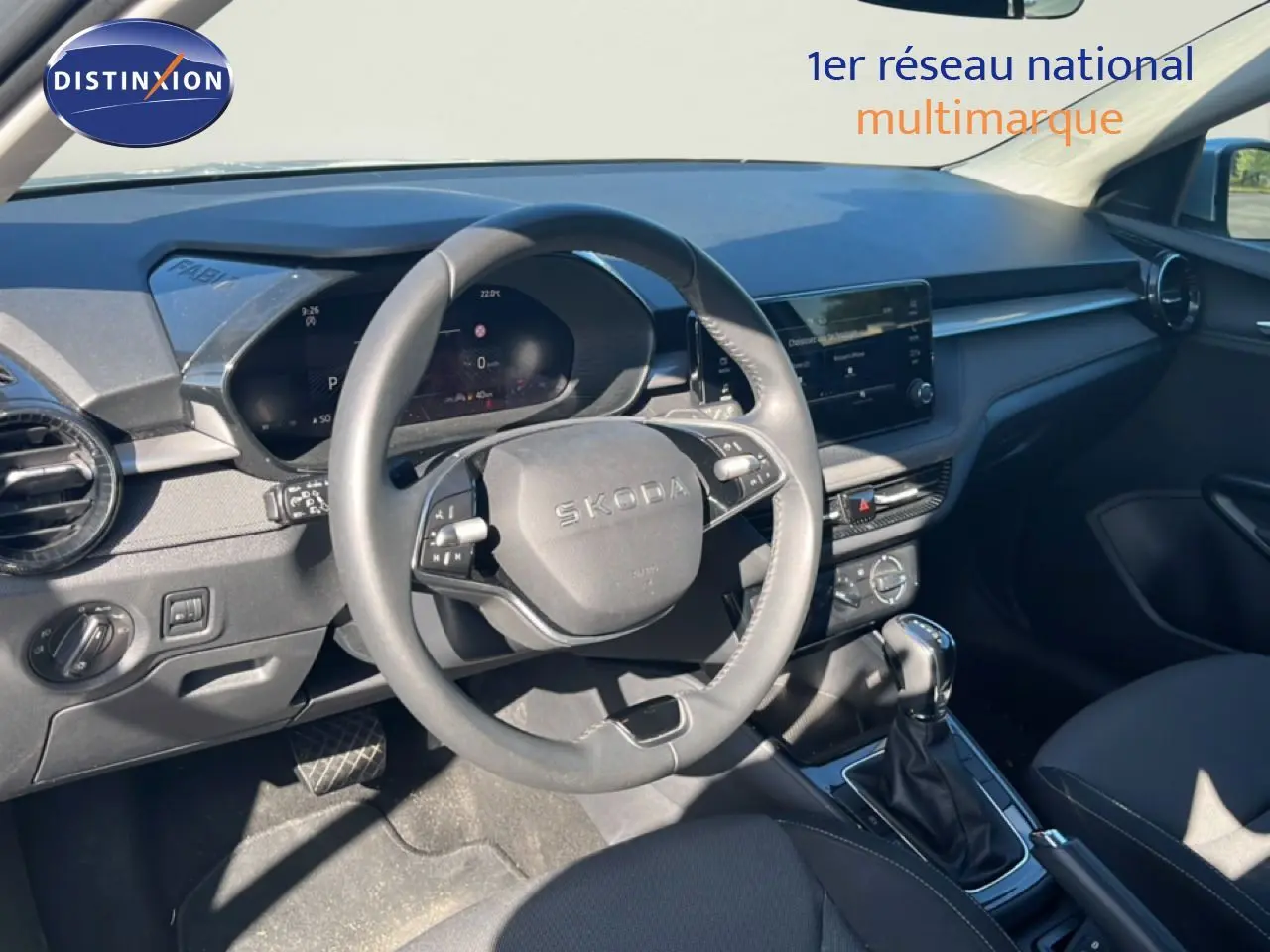 Intérieur de la Skoda Fabia 2025 en vue avant, volant multifonction, tableau de bord numérique et console centrale avec boîte auto.