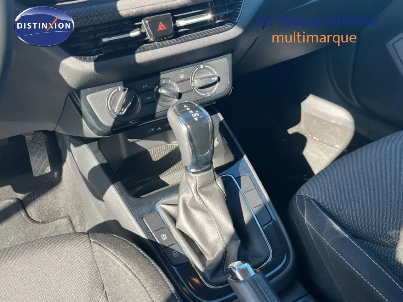 Gros plan sur la console centrale de la Skoda Fabia 2025 en Reflex Silver, mettant en valeur le levier de vitesse automatique et les commandes de climatisation.