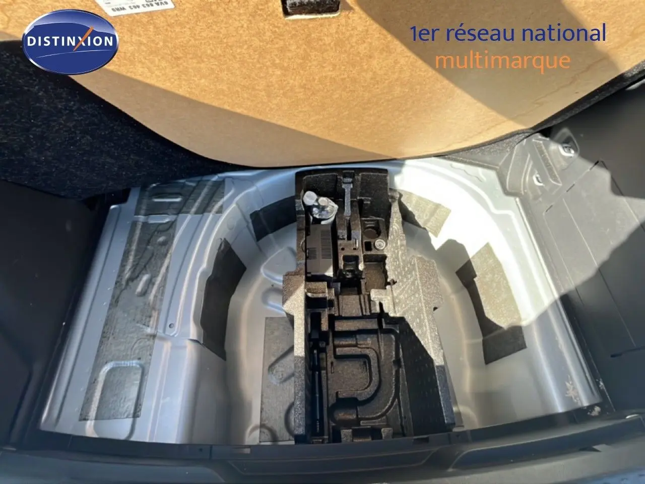 Coffre ouvert d’une Skoda Fabia Reflex Silver Metal 2025, montrant le rangement sous plancher avec outils et espace pour roue de secours.