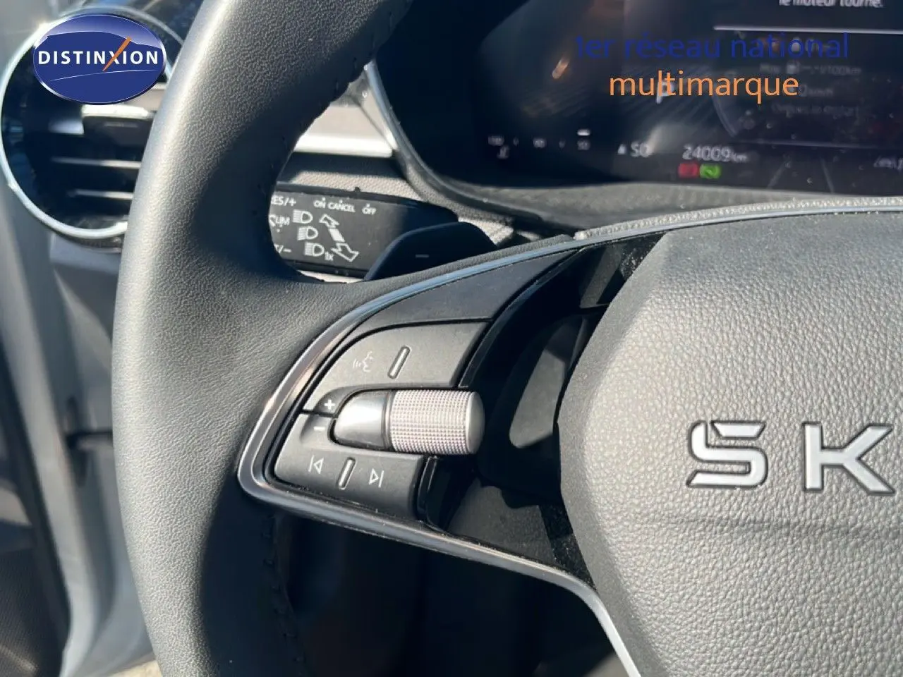 Gros plan sur la partie gauche du volant de la Skoda Fabia 2025, avec commandes intégrées et logo SKODA visible.