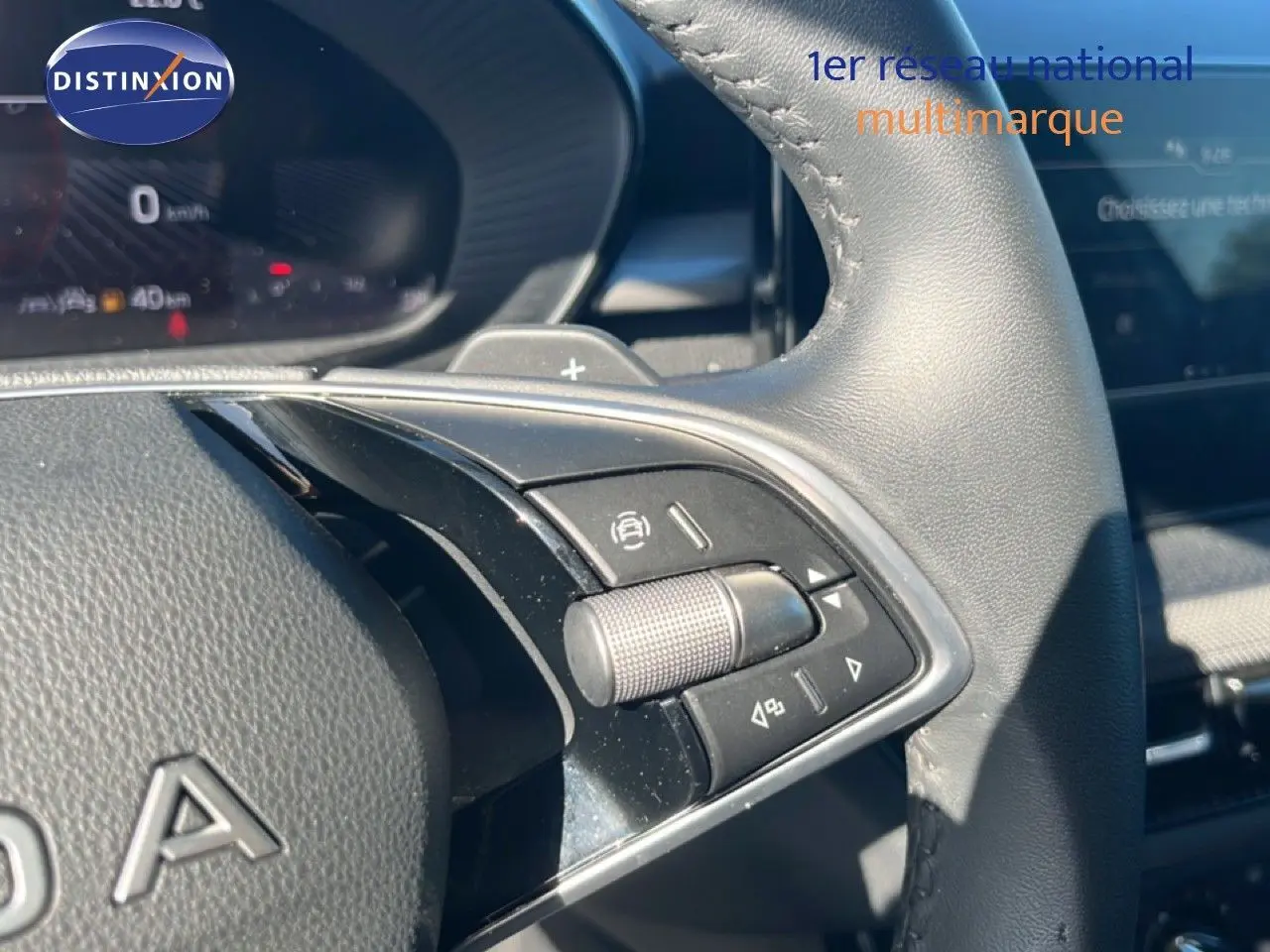 Gros plan sur les commandes multifonctions à droite du volant en cuir noir de la Skoda Fabia 2025.