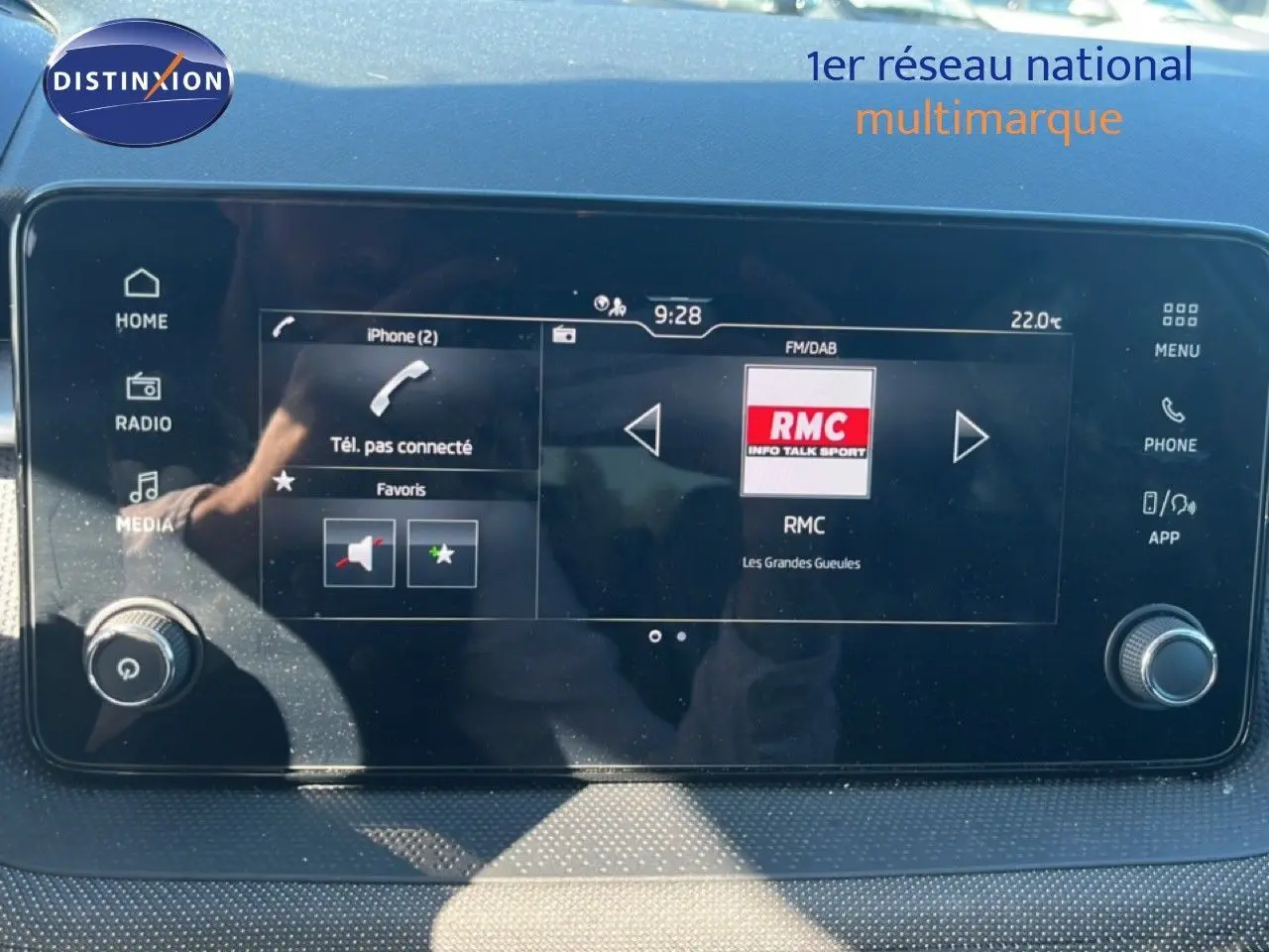 Écran tactile central du Skoda Fabia 2025 affichant la radio RMC, avec commandes multimédia et climatisation visibles.