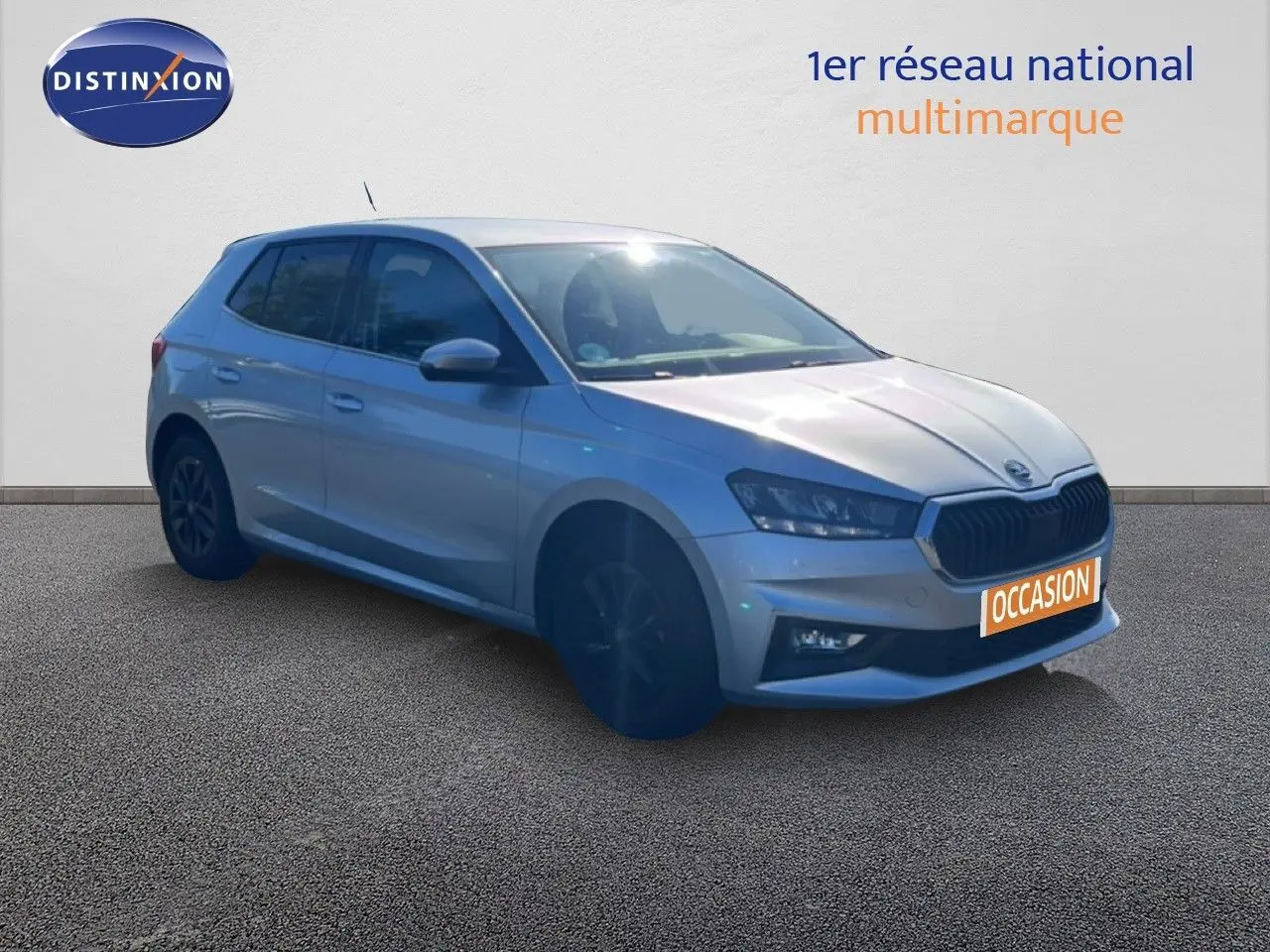 SKODA Fabia 2025 gris argenté en 3/4 avant, avec calandre noire et jantes foncées, sur fond neutre.