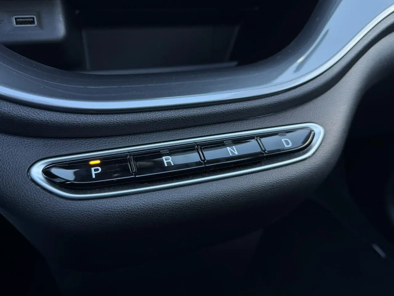 Gros plan sur la commande de boîte automatique noire avec bouton P allumé dans une Fiat 500 Cabriolet électrique 2024.