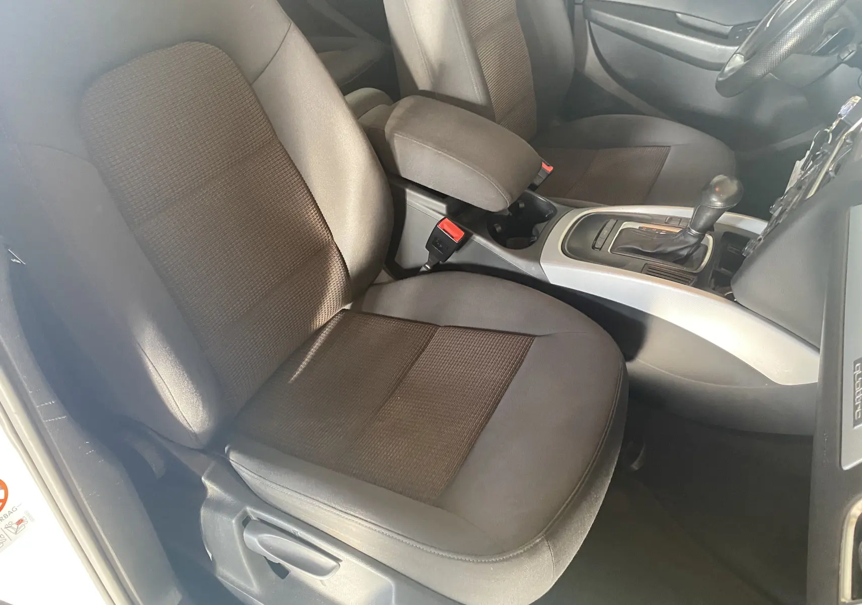 Vue intérieure côté conducteur de l'Audi Q5 2012, sièges gris foncé avec console centrale et levier de vitesse automatique.