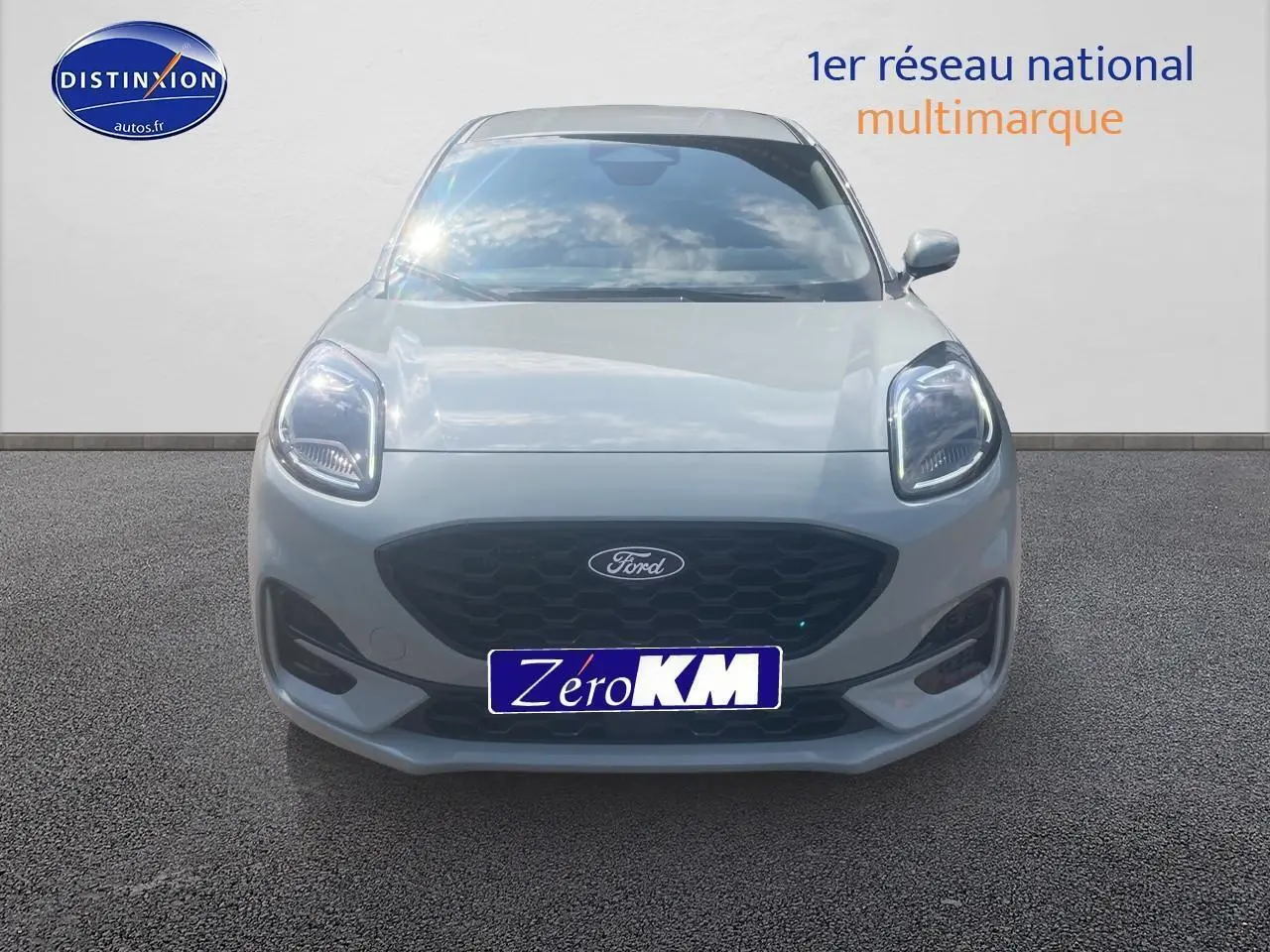 Vue frontale d'un Ford Puma 2025 gris cactus avec calandre noire et phares LED allumés sur fond neutre.