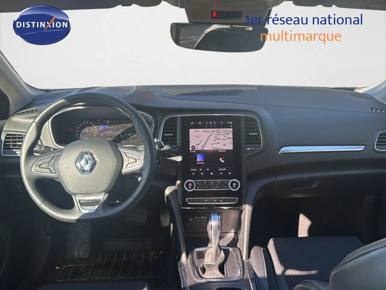 Vue intérieure avant de la Renault Mégane Break 2024 gris titanium, tableau de bord et console centrale avec écran tactile.