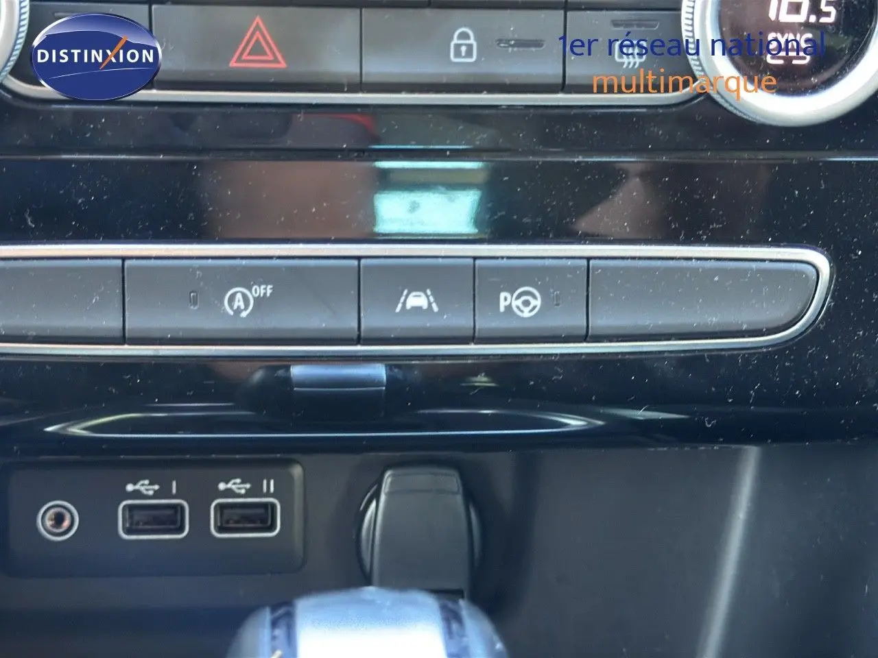 Vue rapprochée de la console centrale avec boutons de contrôle, ports USB et levier de boîte automatique sur Renault Mégane Break gris titanium.