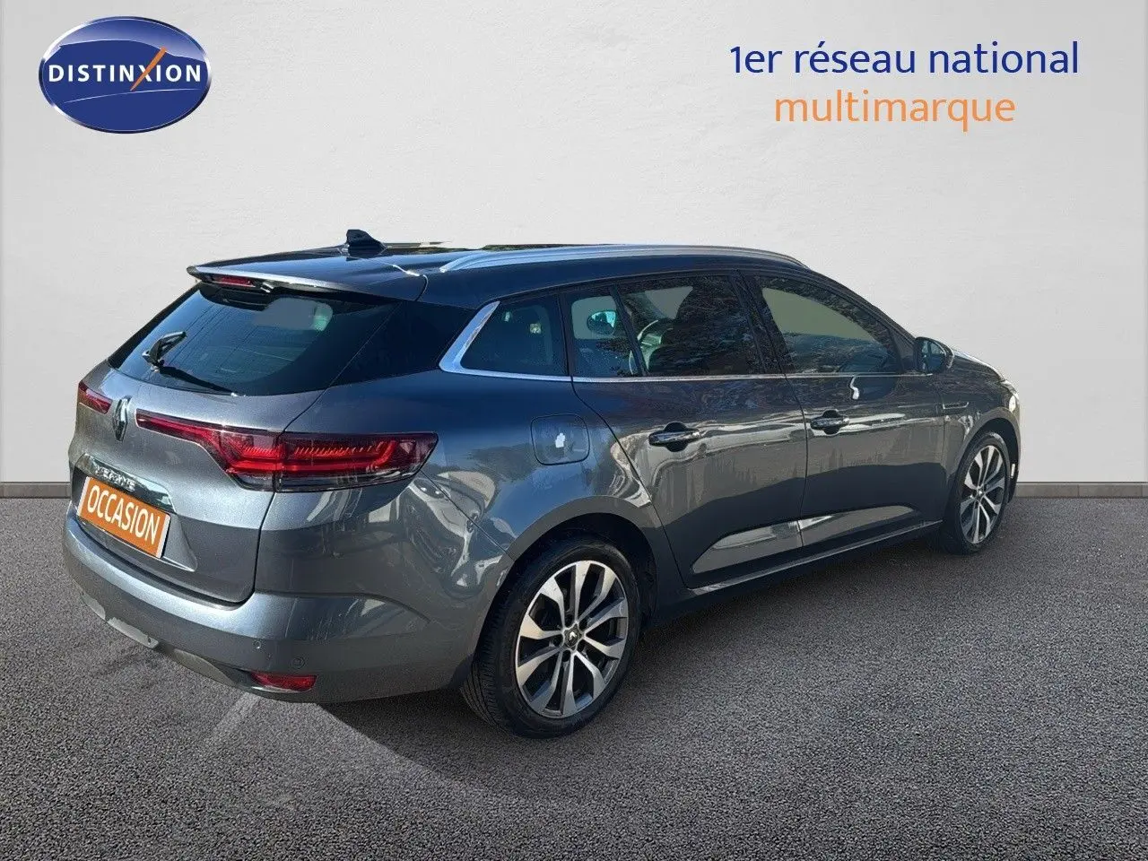 Renault Mégane Break gris titanium métal vue 3/4 arrière droit, jantes alliage et feux LED distinctifs.