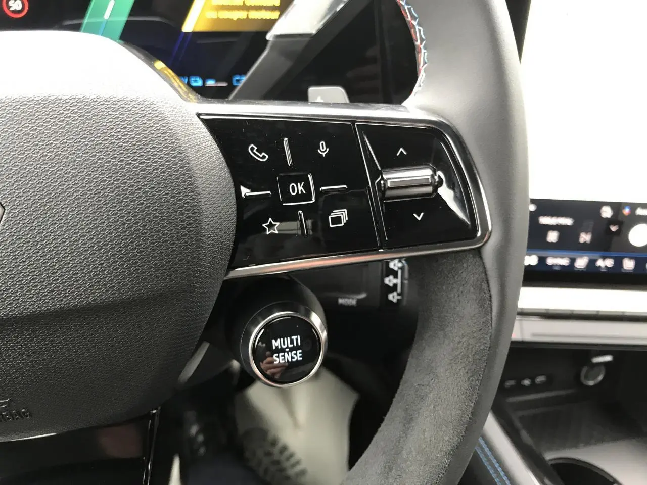 Gros plan sur le volant noir avec commandes tactiles et molette Multi-Sense du Renault Austral hybride 2025.