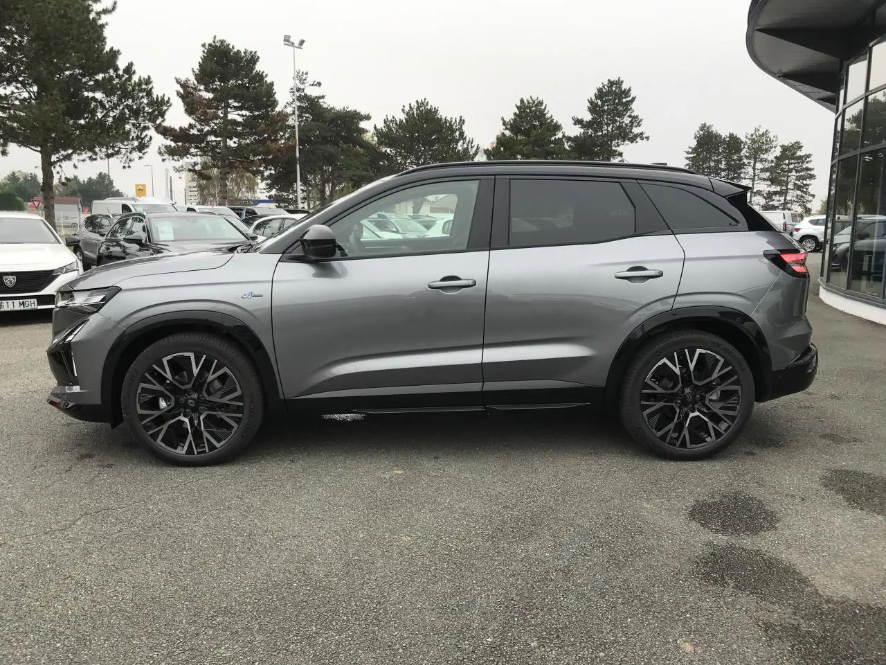 Renault Austral full hybrid gris métallisé avec toit noir, vue profil côté gauche, jantes alliage 20 pouces.