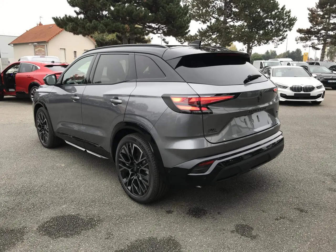 Vue 3/4 arrière d'un Renault Austral gris métallisé avec toit noir et jantes alliage noires diamantées.