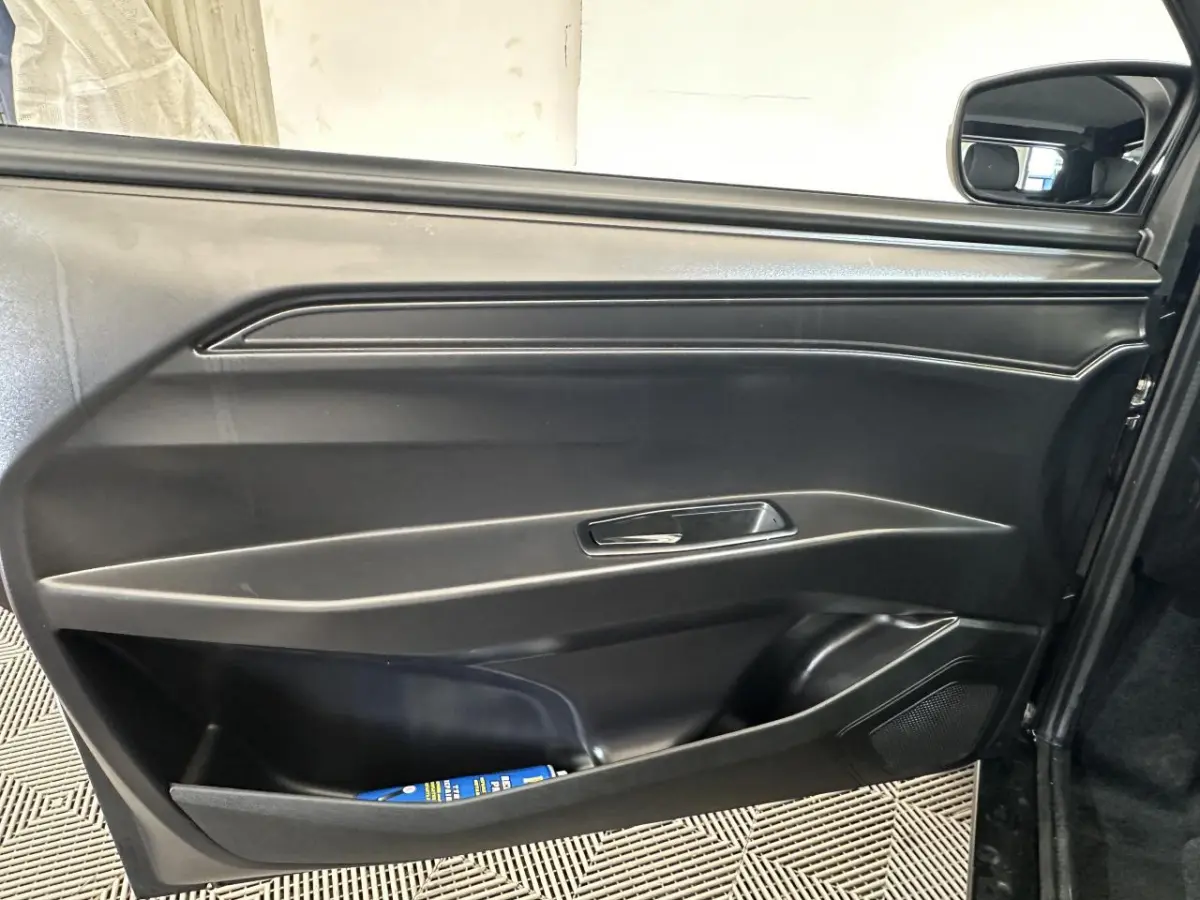 Vue intérieure sur la porte conducteur noire de l'AIXAM MINAUTO E ACCESS 2026 avec rétroviseur caméra côté gauche visible.