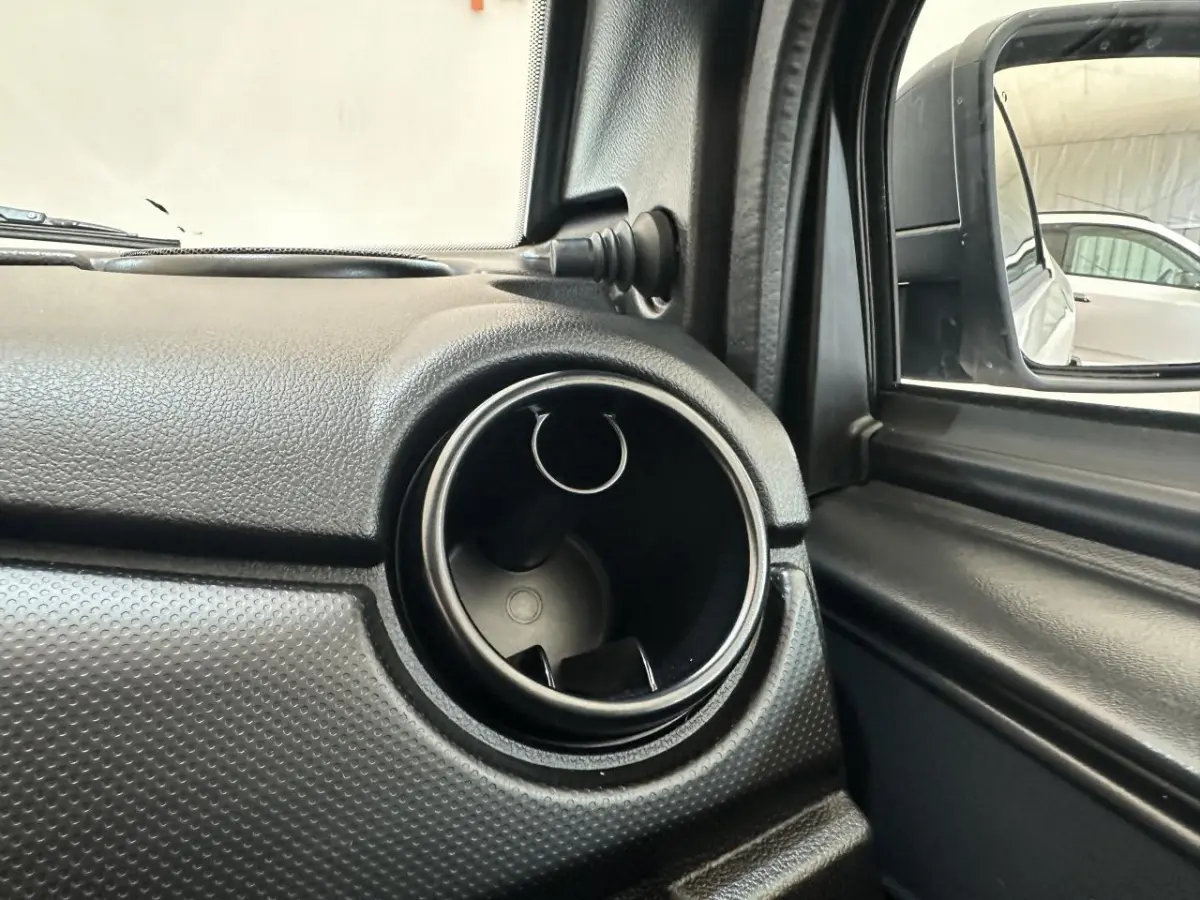 Détail de la sortie d'air circulaire côté conducteur de l'AIXAM MINAUTO E ACCESS 2026 blanc, avec rétroviseur extérieur caméra.