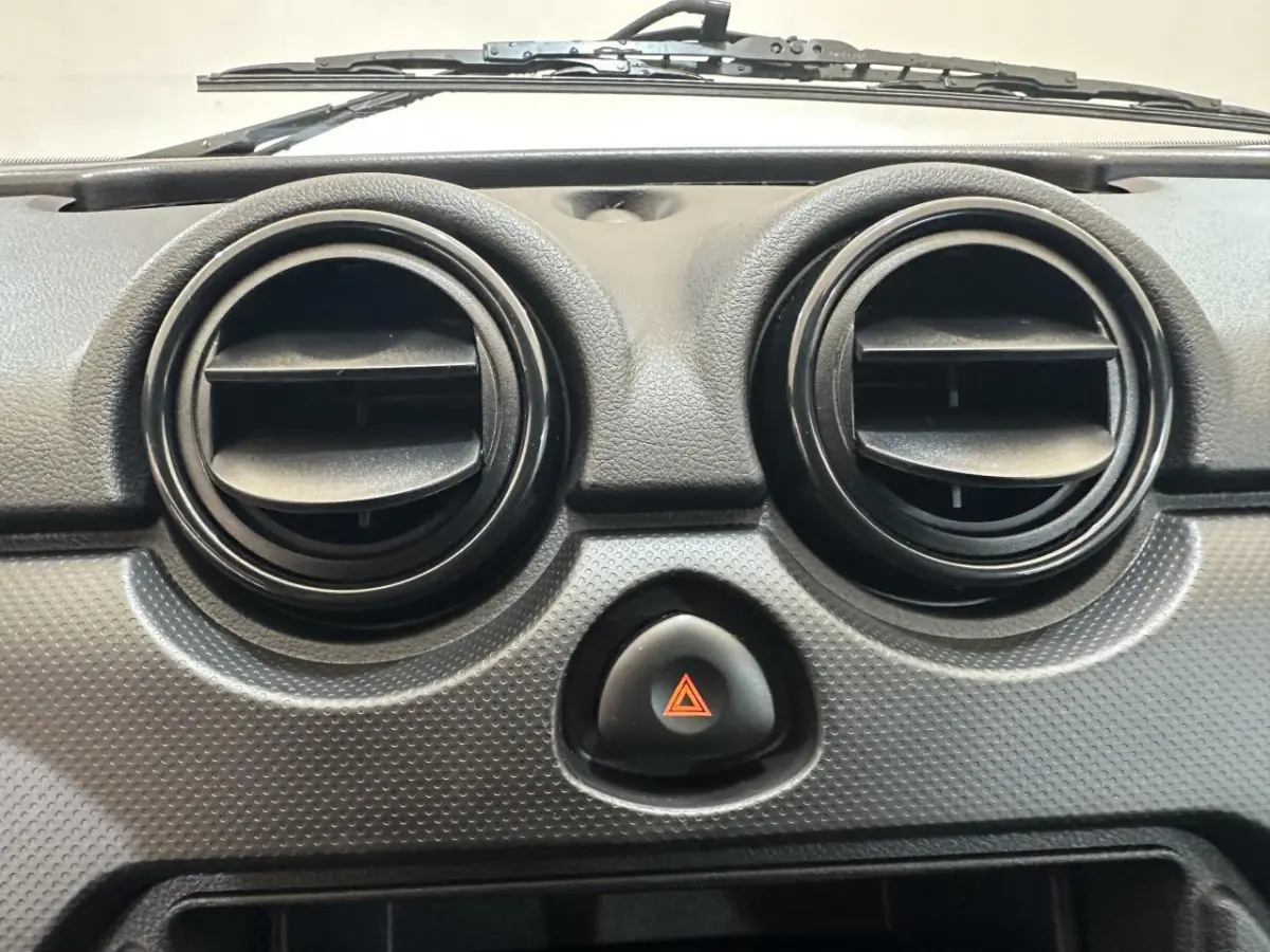 Détail du tableau de bord de l'AIXAM MINAUTO E ACCESS 2026 montrant les deux aérateurs ronds noirs et le bouton de warning central.