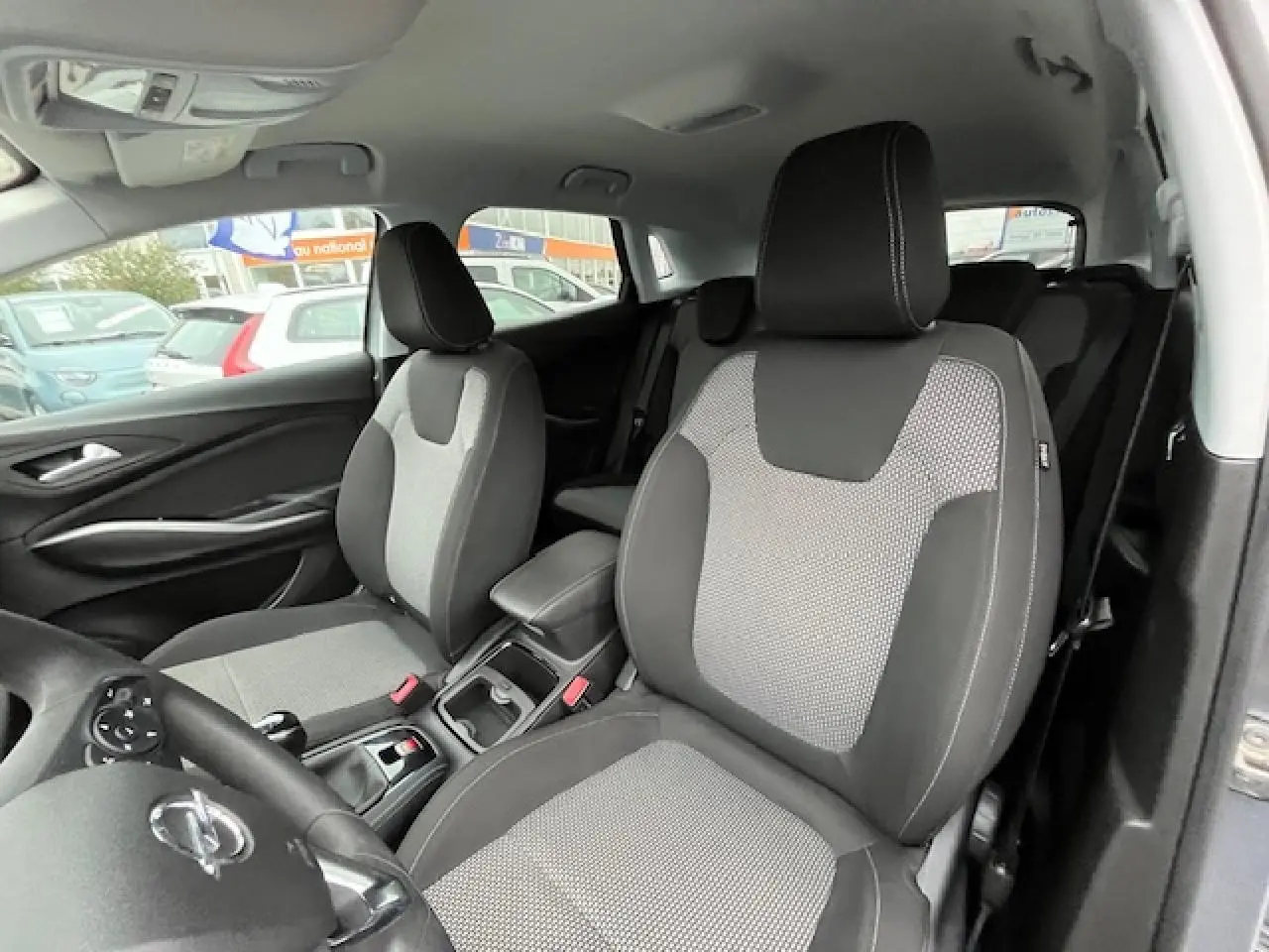 Vue intérieure avant droite de l’Opel Grandland X gris 2020, sièges tissu bicolore avec coutures contrastées.