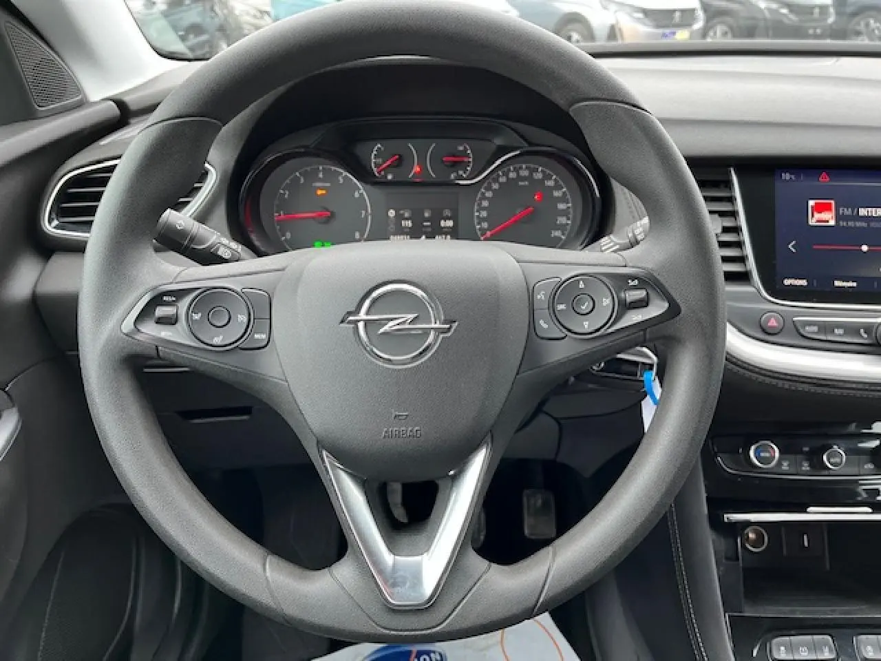 Vue centrée sur le volant gris de l'Opel Grandland X 2020 avec tableau de bord et écran multimédia visibles.