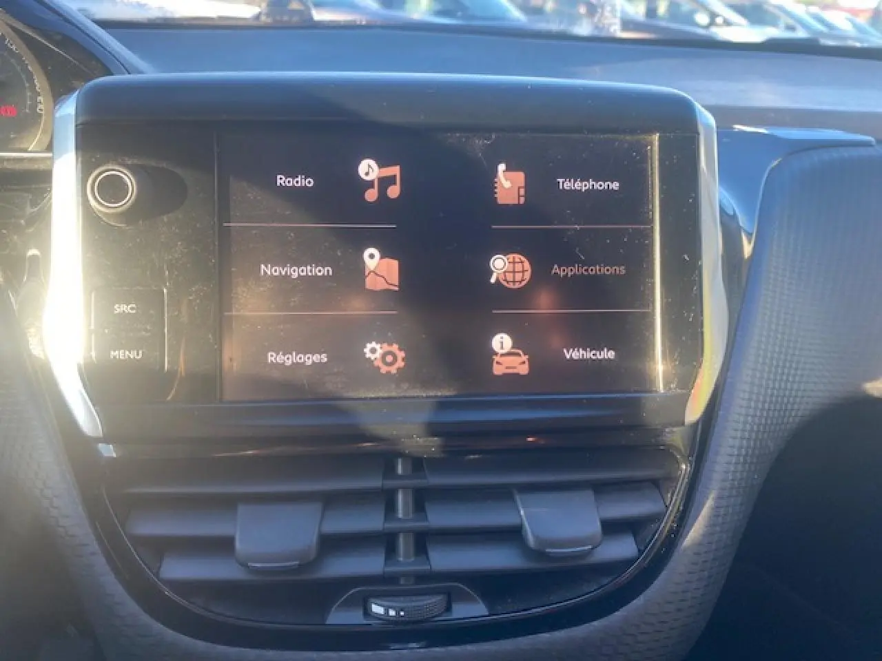 Vue rapprochée de l’écran tactile multifonction 7 pouces du Peugeot 2008 gris Artense, affichant les options radio et navigation.