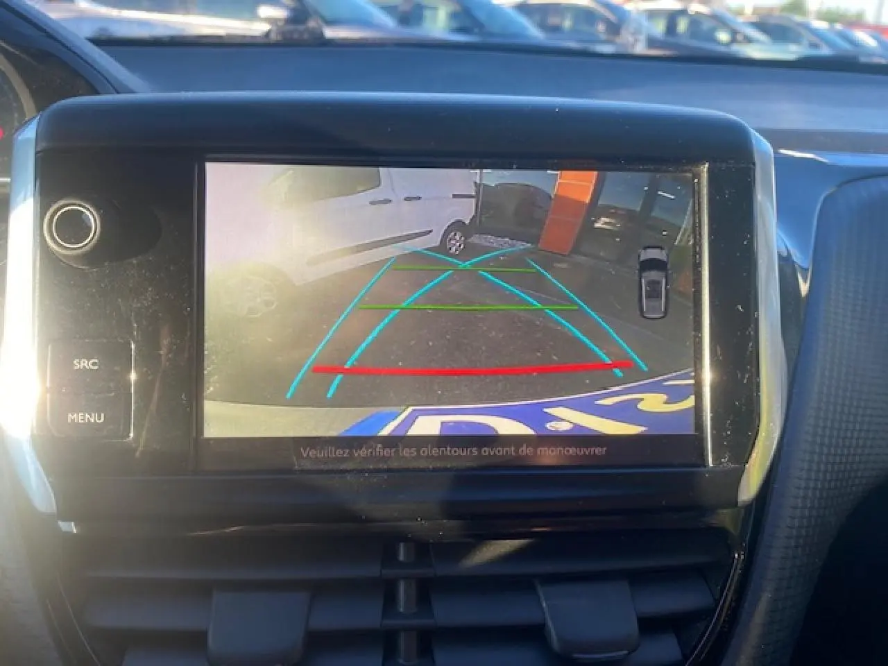 Écran tactile intérieur montrant la caméra de recul du Peugeot 2008 gris Artense avec lignes de guidage colorées.