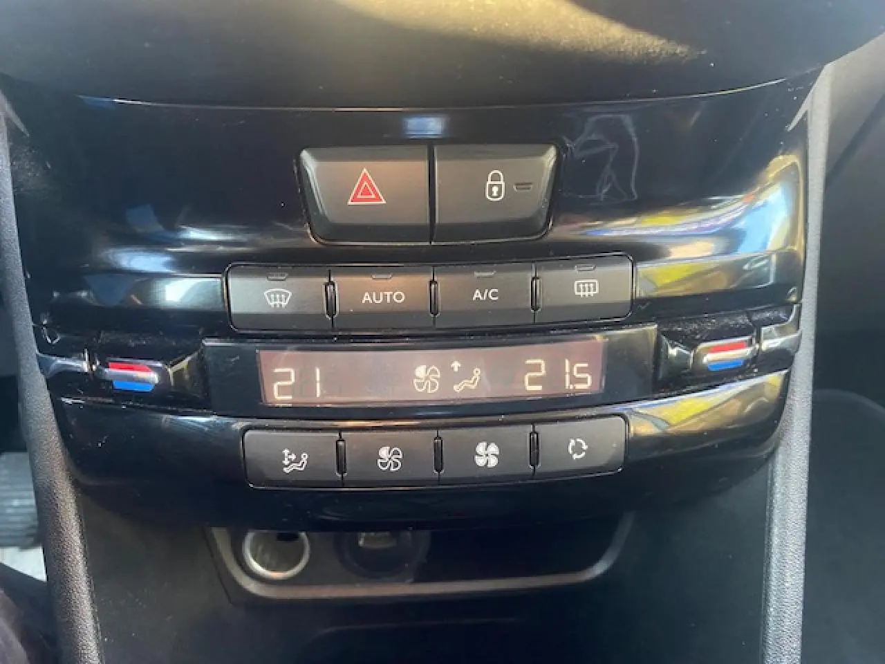 Vue rapprochée du tableau de bord noir du Peugeot 2008 2019, montrant les commandes de la climatisation automatique bi-zone.
