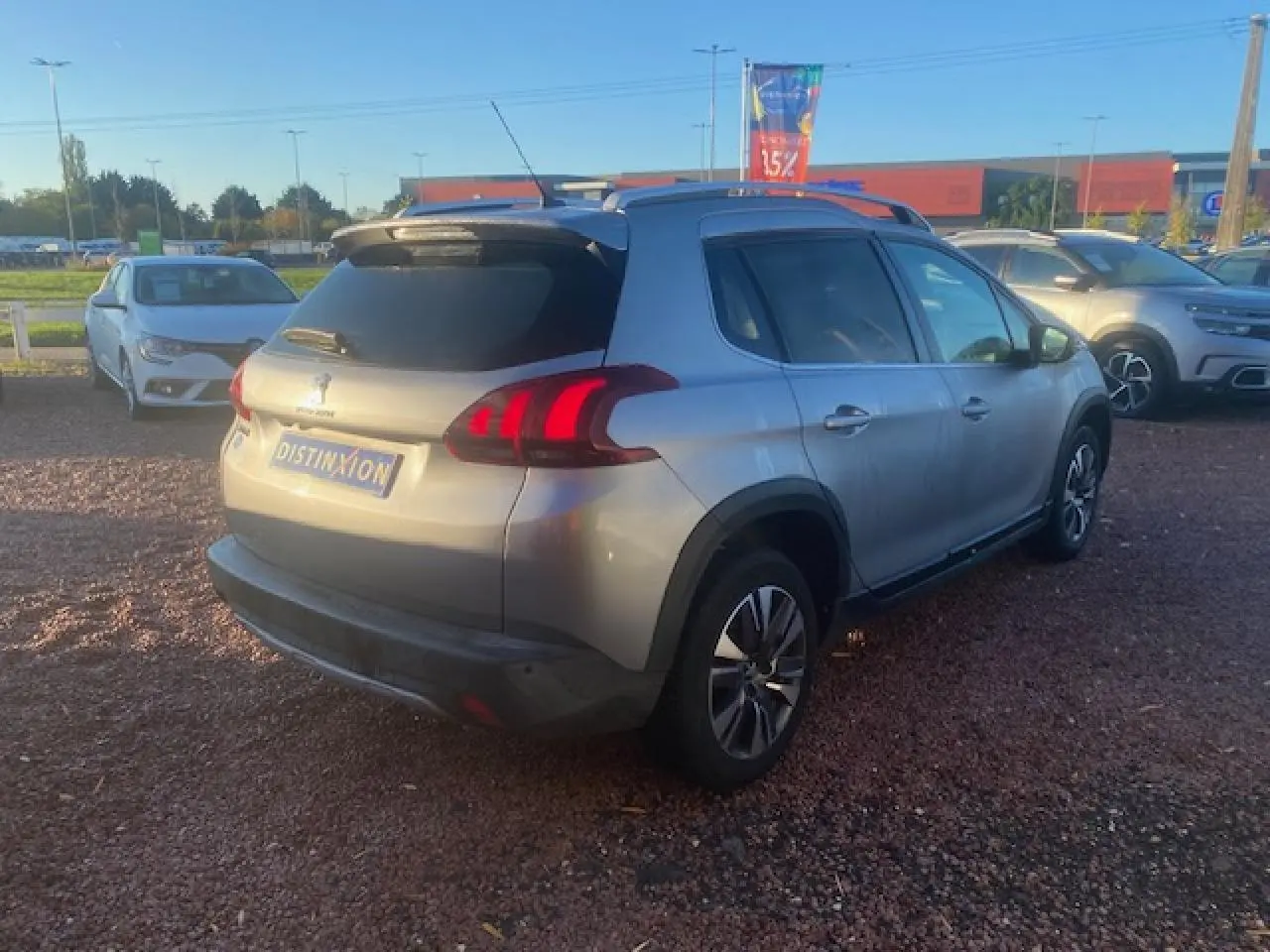 Peugeot 2008 gris Artense vue 3/4 arrière droit, jantes aluminium 16 pouces et vitres arrière surteintées.