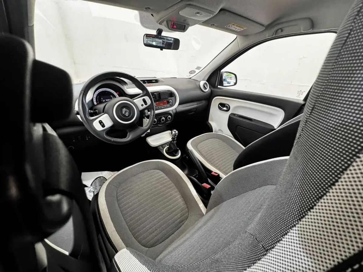 Vue intérieure avant droite de la Renault Twingo Intense Energy TCe 90 avec sièges gris et volant cuir multifonctions.