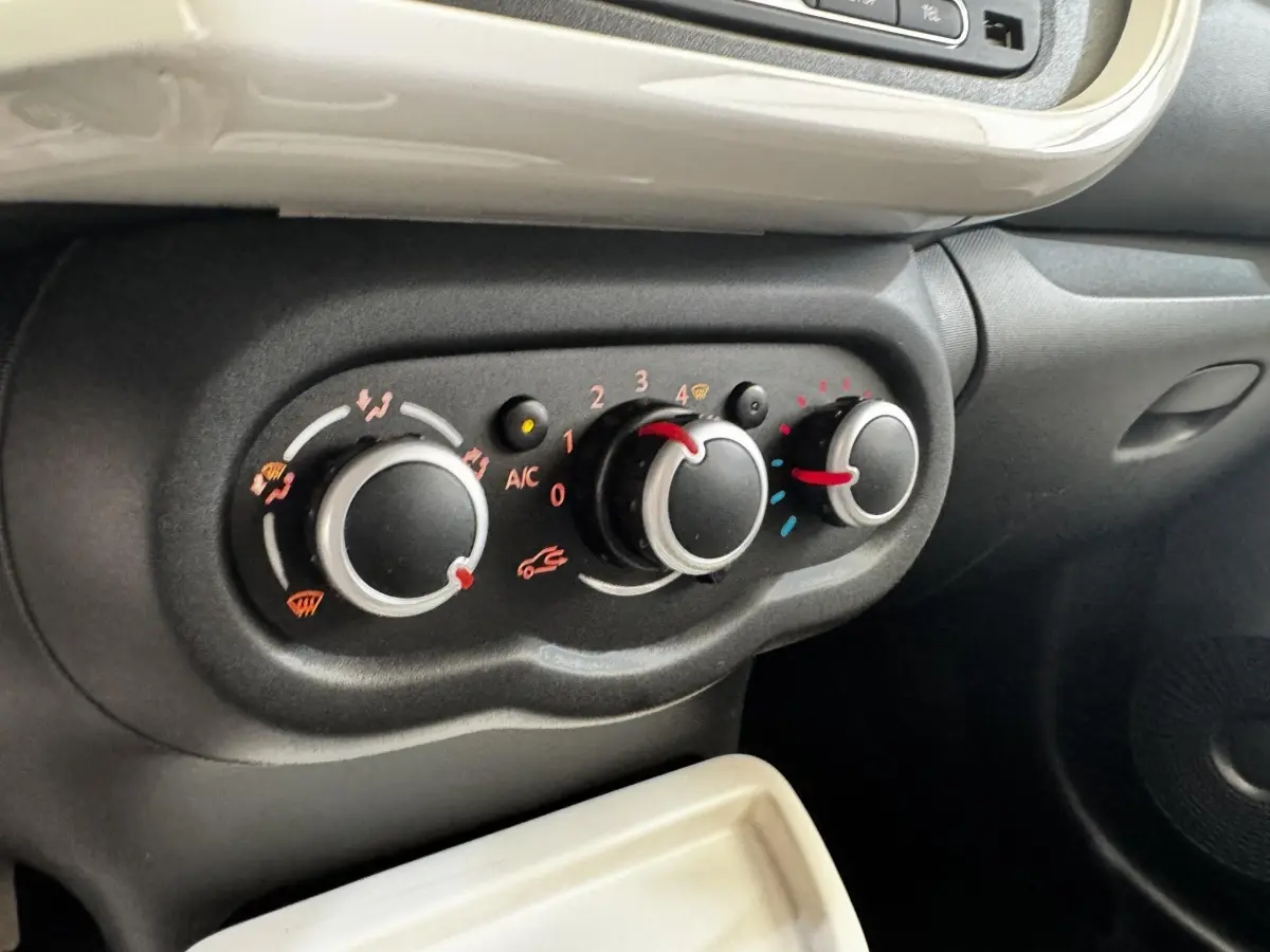 Gros plan sur les commandes de climatisation noires et grises de la Renault Twingo gris foncé, version Intense Energy TCe 90.