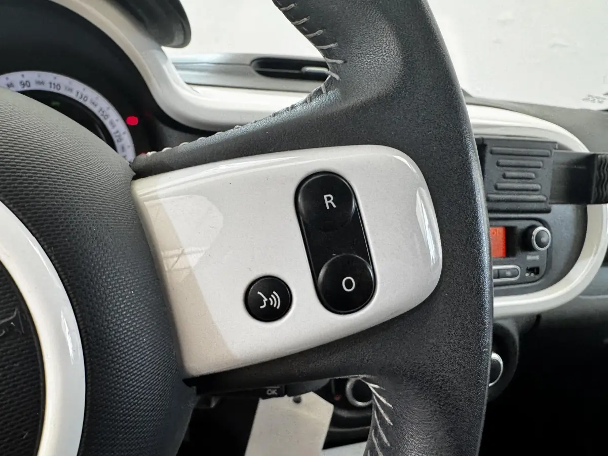 Gros plan sur le volant cuir noir et blanc avec commandes vocales de la Renault Twingo Intense Energy TCe 90 gris foncé, 2016.
